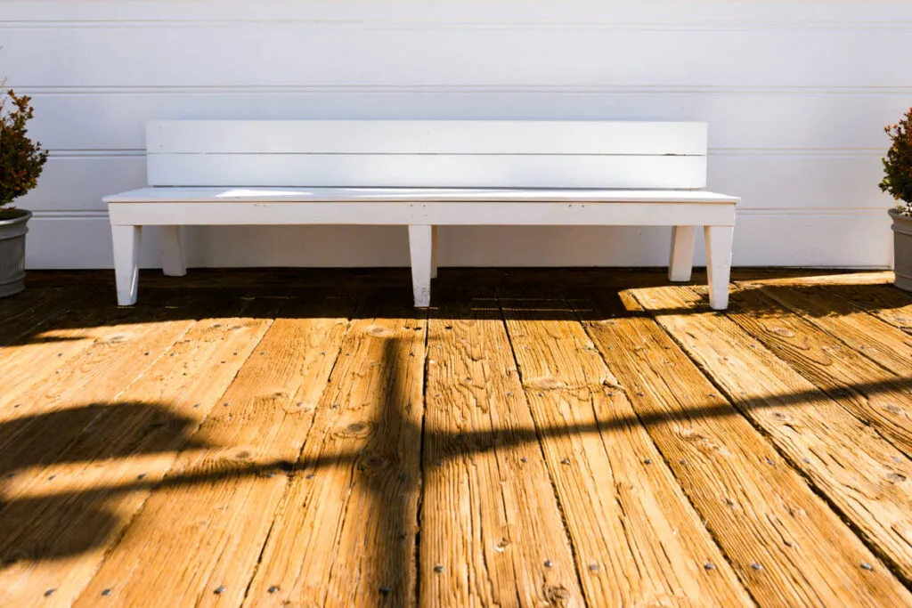 White bench on a wooden deck