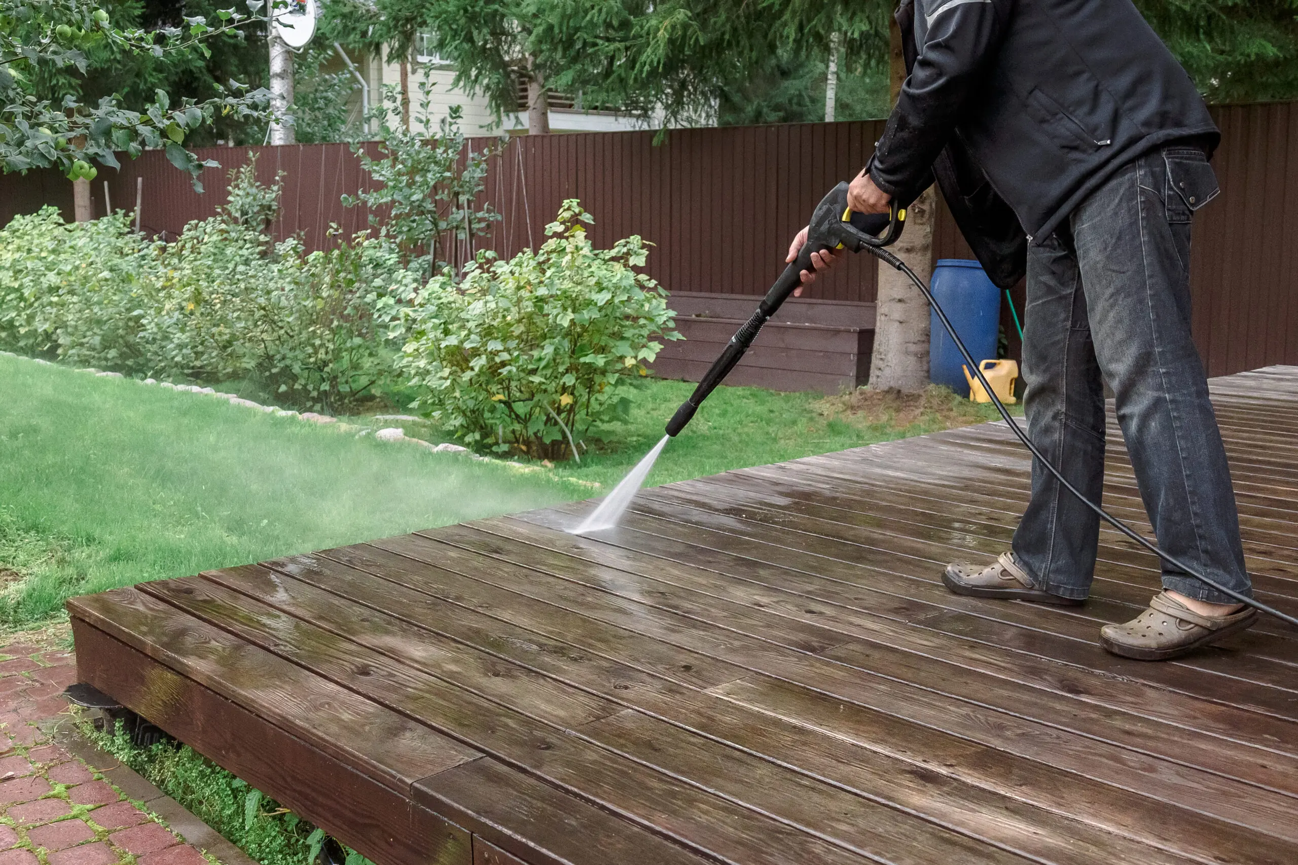 Man cleaning deck with high pressure