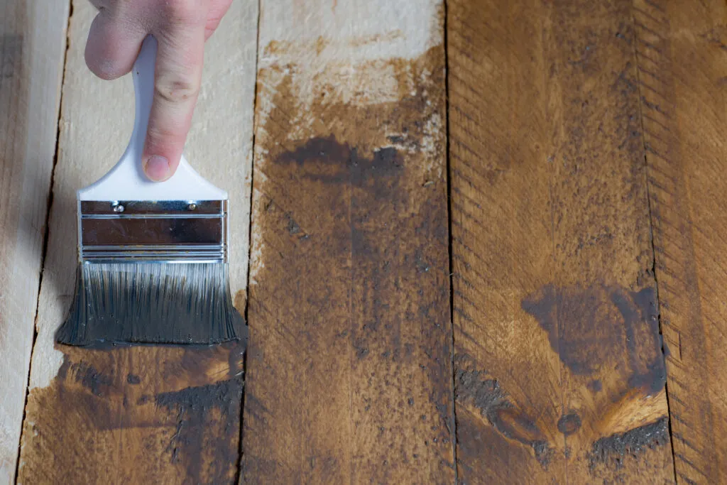 close up person shows how to restain your deck