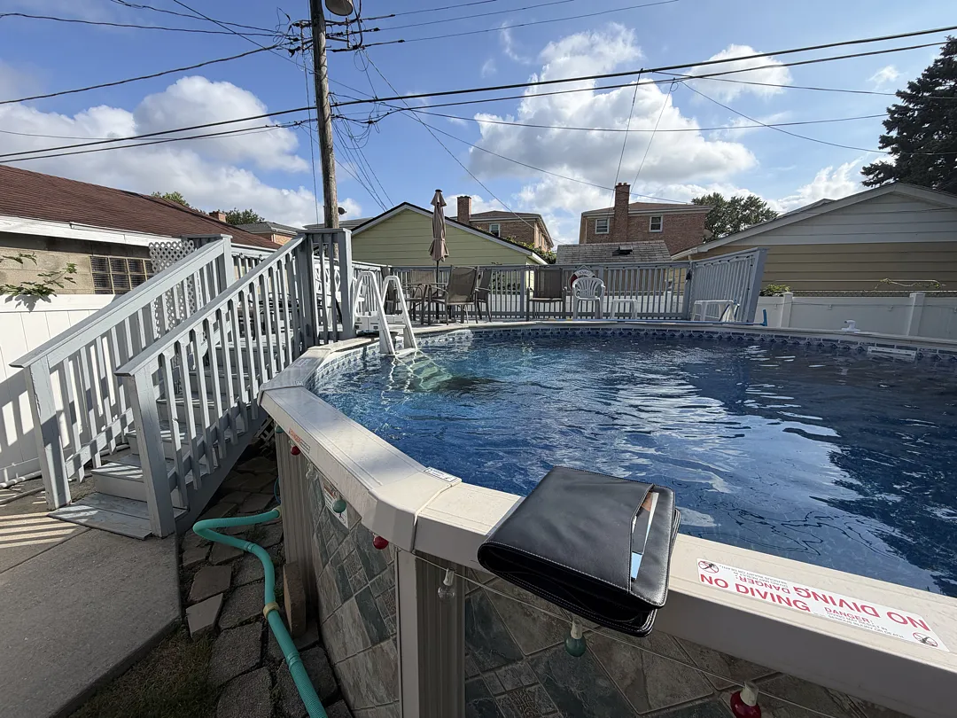 Wood pool deck with gray railings and stairs around an above-ground pool in Chicago 60630
